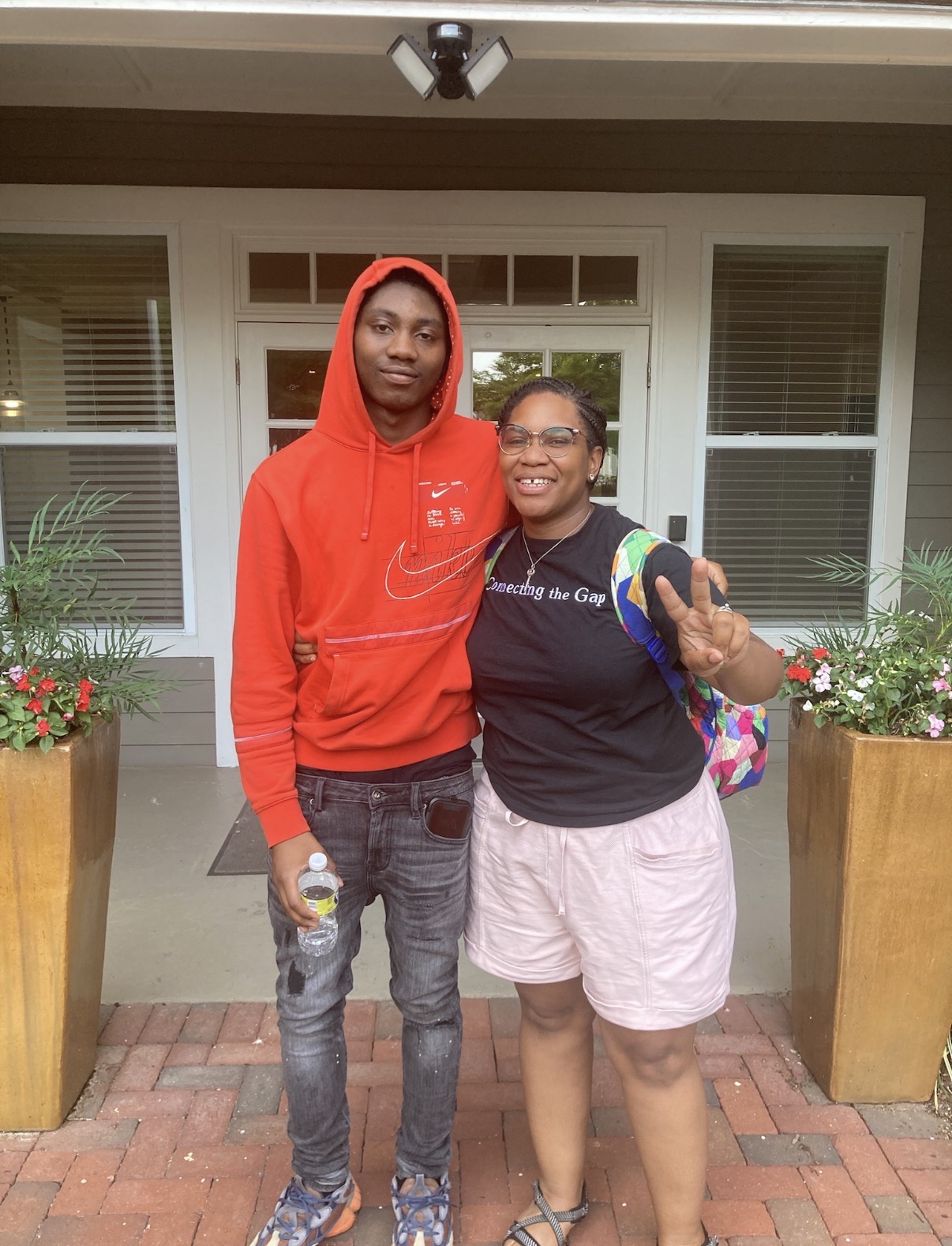 A Connecting the Gap mentor and a young man smiling together outside.